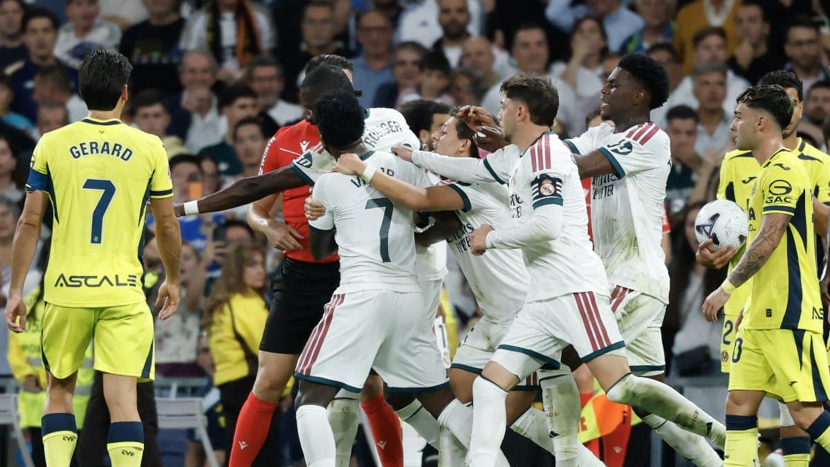 El delantero brasileño del Real Madrid, el número 7 Vinicius Junior (centro), es sujetado por sus compañeros.