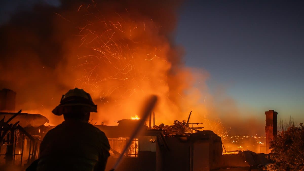 Un bombero lucha contra el incendio Norte Fire mientras este arrasa una casa en San Juan Capistrano, California