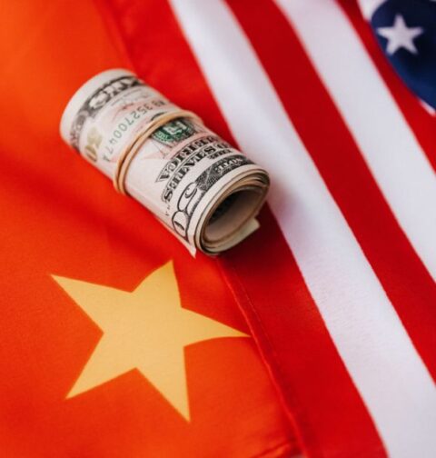 Chinese flag and USA flag with some dollars