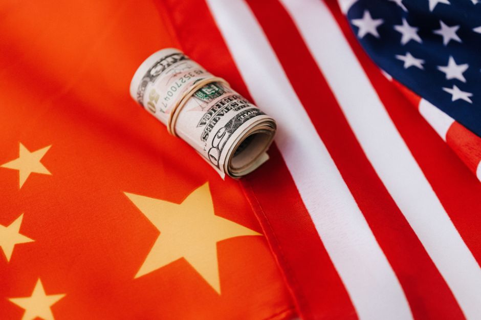 Chinese flag and USA flag with some dollars