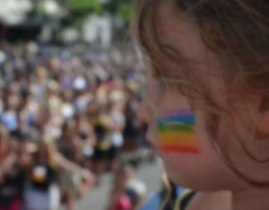 Una niña con la bandera LGBT pintada en la cara durante el desfile del Orgullo gay.