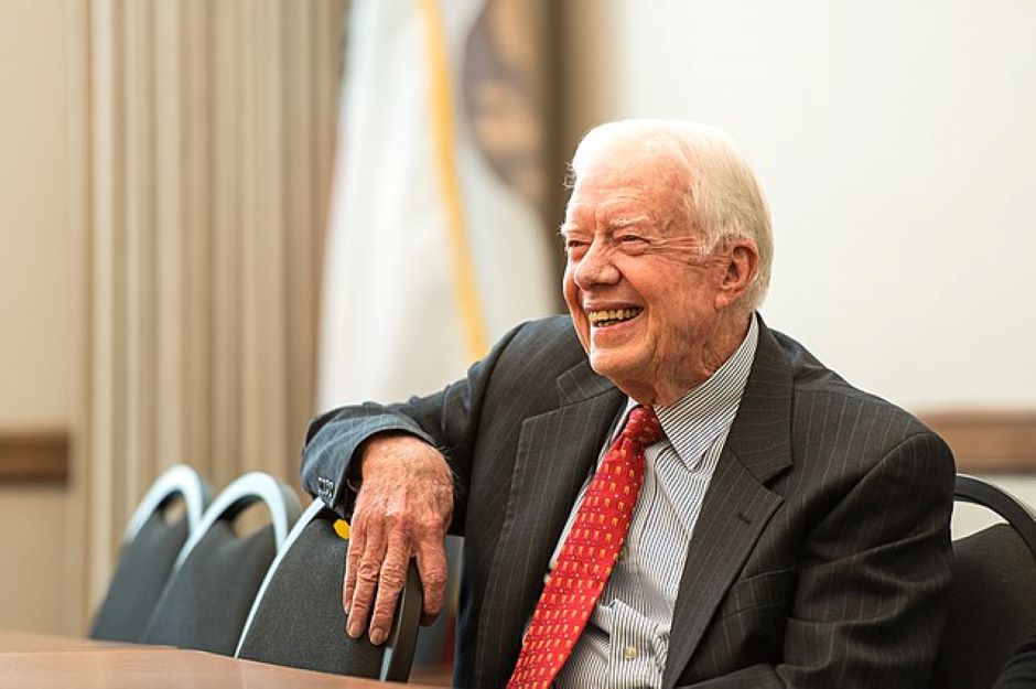 Jimmy Carter sentado sonriendo durante el año 2013.