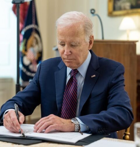 El presidente Joe Biden firma en el despacho oval.