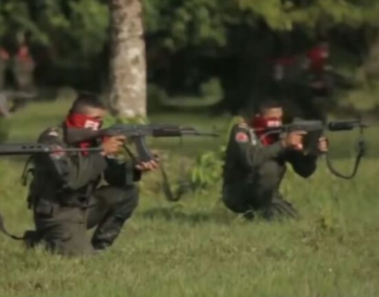 Mimebros del ELN práctican en un campo de tiro con armas largas.