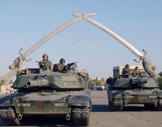 Tankes Abraham posan para una foto bajo el "Arco de la Victoria" en la Plaza de la Ceremonia, Bagdad, Irak, durante la Operación Libertad Iraquí.