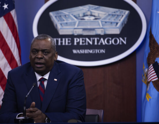 El secretario de Defensa Lloyd J. Austin III hablando frente a un cartel del pentágono.