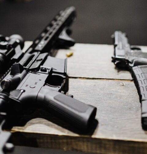 Un rifle de asalto y una pistola en un campo de entrenamiento de tiro. Imagen de archivo.