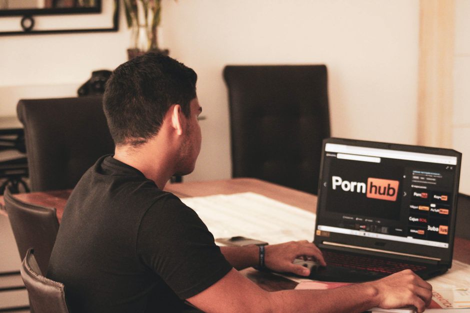 Joven consultando el sitio web de contenido para adultos Pornhub.